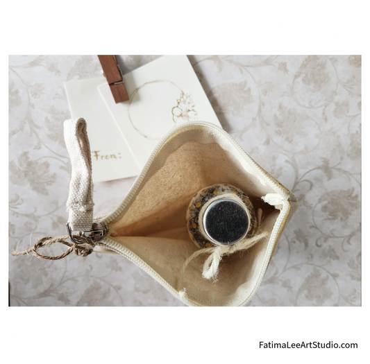 A set of elegant wedding favors including a glass jar with lavender bath salts, a thank you card, and a cotton pouch with a floral design,